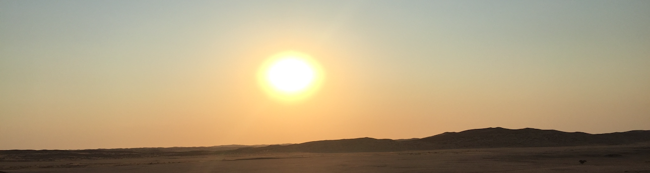Contact page header image of desert with setting sun and sky.